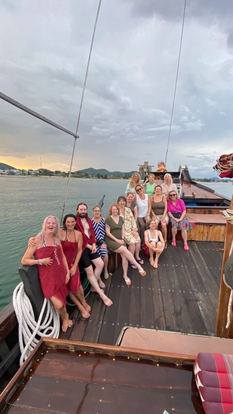 Die Retreat-Gruppe lachend auf dem Deck eines Holzboots