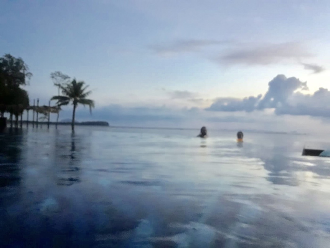 Infinity-Pool mit Blick aufs Meer in der Abenddämmerung